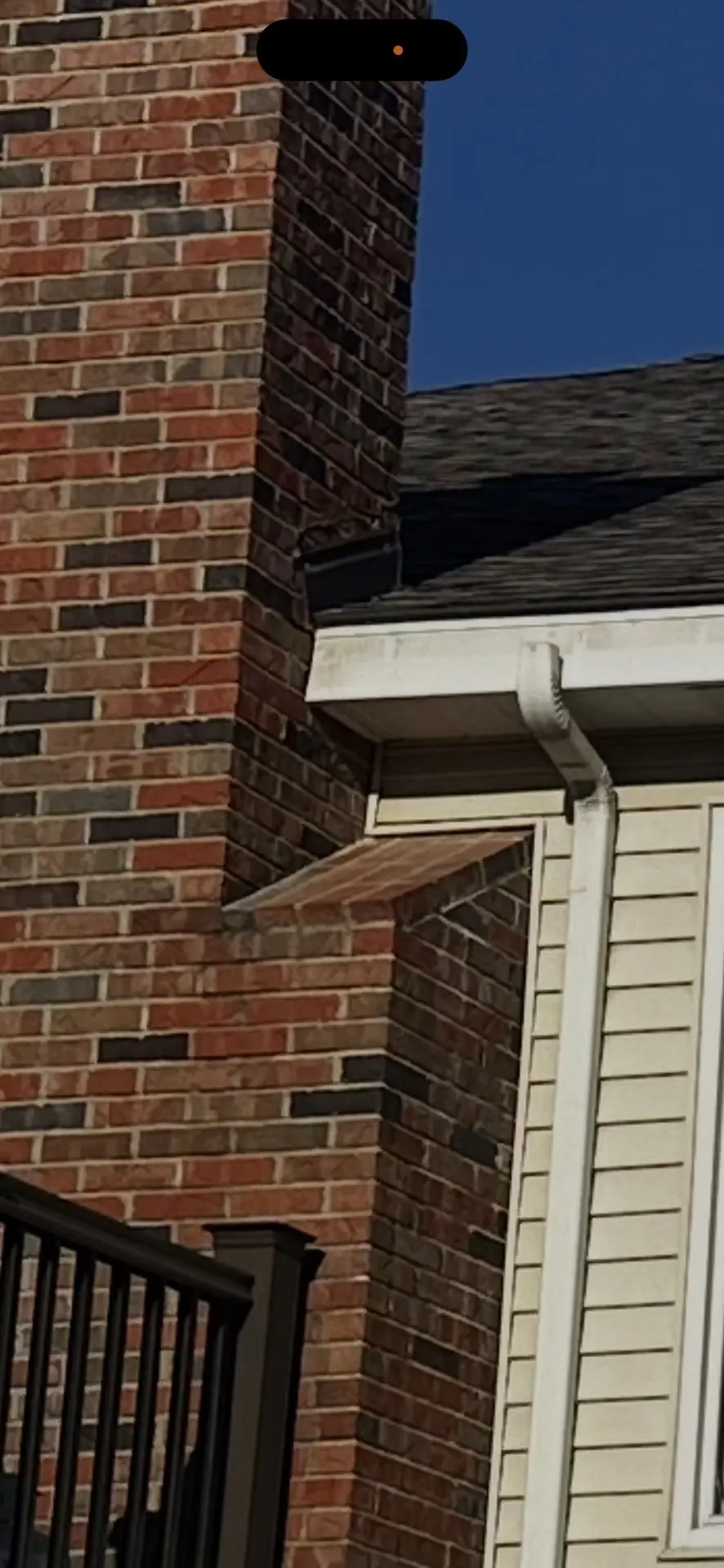 Finished shingles and flashing at the brick chimney