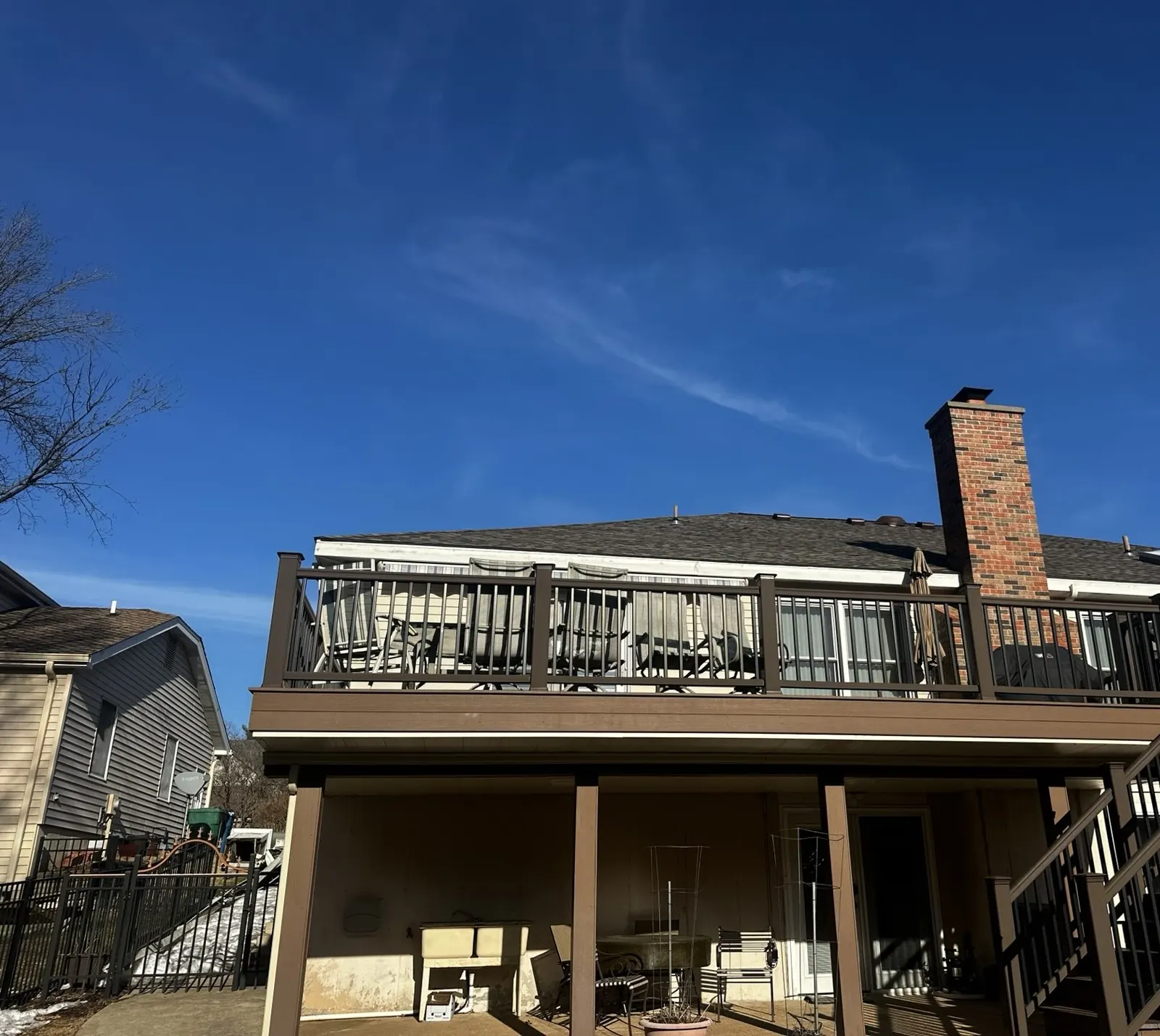 Finished roof over the rear deck and brick chimney under a blue sky