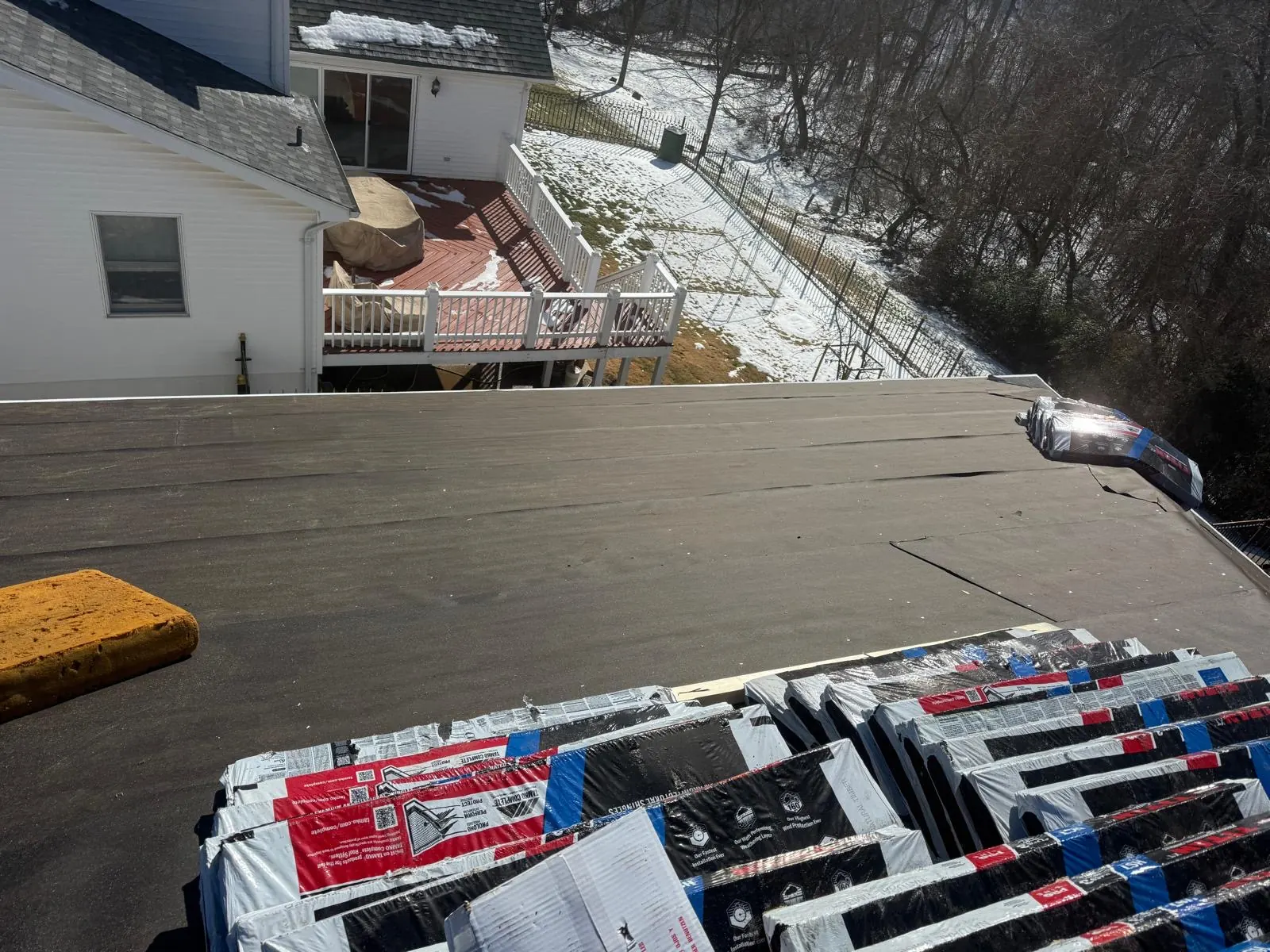 Bundles of new shingles staged on fresh underlayment